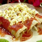 Papadzules yucatecos, servidos con salsa de pepitas y huevo cocido.